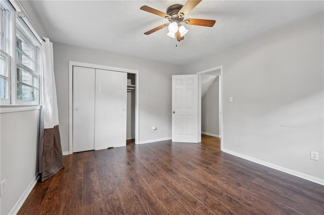 unfurnished bedroom with dark hardwood / wood-style flooring, ceiling fan, and a closet