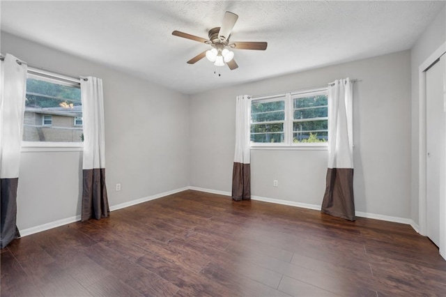 spare room with dark hardwood / wood-style floors and ceiling fan