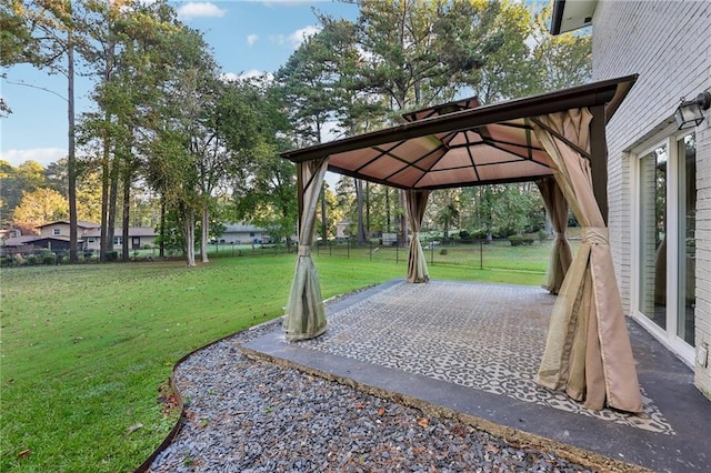 view of community featuring a yard, a patio, and a gazebo