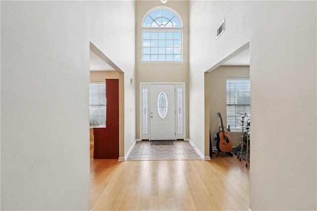 entrance foyer with a wealth of natural light, visible vents, and light wood-style floors