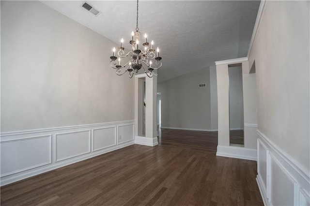 unfurnished dining area featuring dark hardwood / wood-style flooring and an inviting chandelier