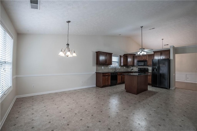 kitchen with decorative light fixtures, dark brown cabinets, vaulted ceiling, a kitchen island, and black appliances