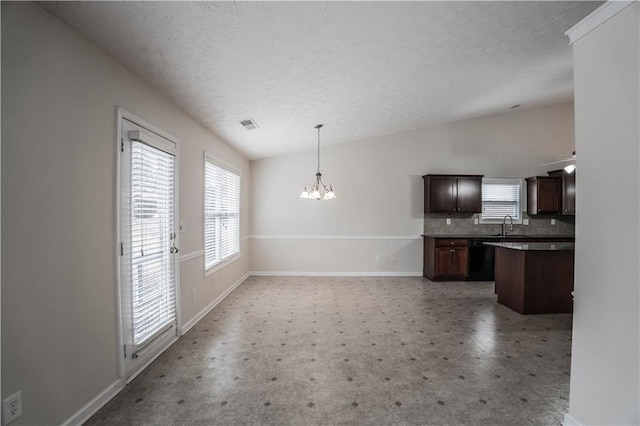 kitchen featuring vaulted ceiling, a notable chandelier, pendant lighting, black dishwasher, and dark brown cabinets