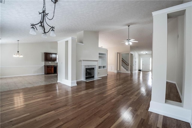 unfurnished living room featuring vaulted ceiling, a high end fireplace, and a textured ceiling