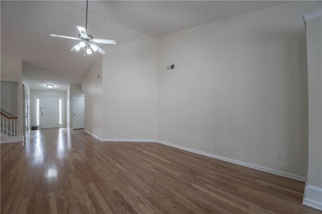 spare room with ceiling fan, dark wood-type flooring, and high vaulted ceiling