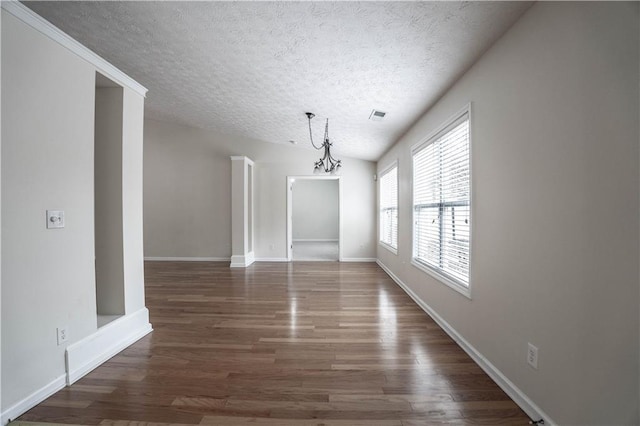 spare room featuring a textured ceiling, dark hardwood / wood-style flooring, and lofted ceiling