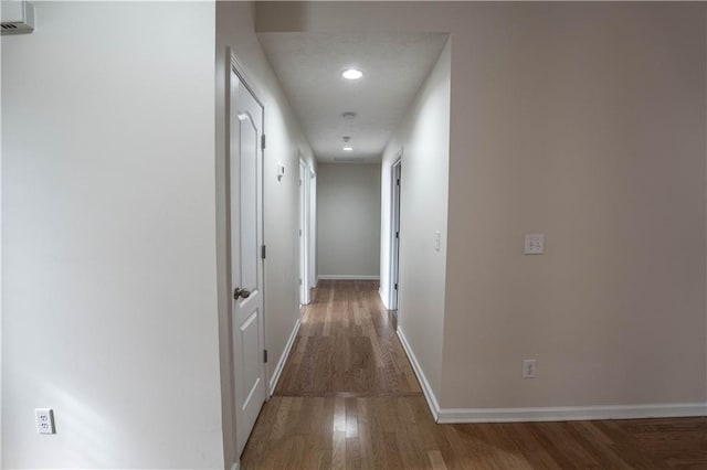 hallway with hardwood / wood-style floors