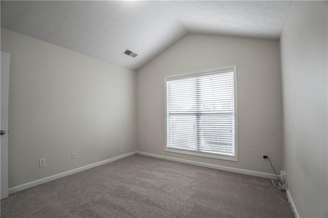 unfurnished room with lofted ceiling, carpet, and a textured ceiling