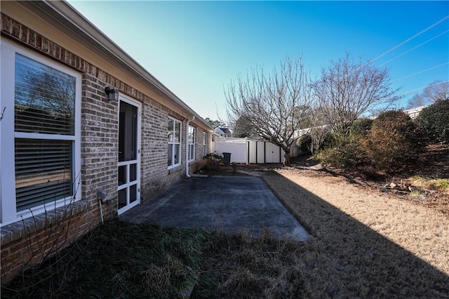 view of yard featuring a storage unit and a patio