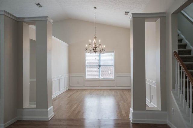 interior space featuring lofted ceiling, a notable chandelier, a textured ceiling, and hardwood / wood-style floors