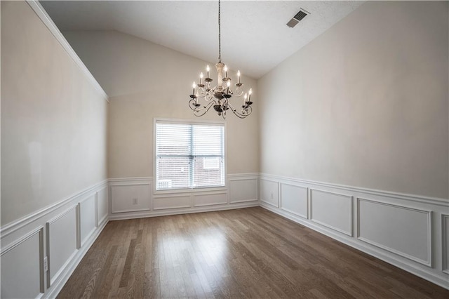 unfurnished room featuring dark hardwood / wood-style flooring, a notable chandelier, and vaulted ceiling