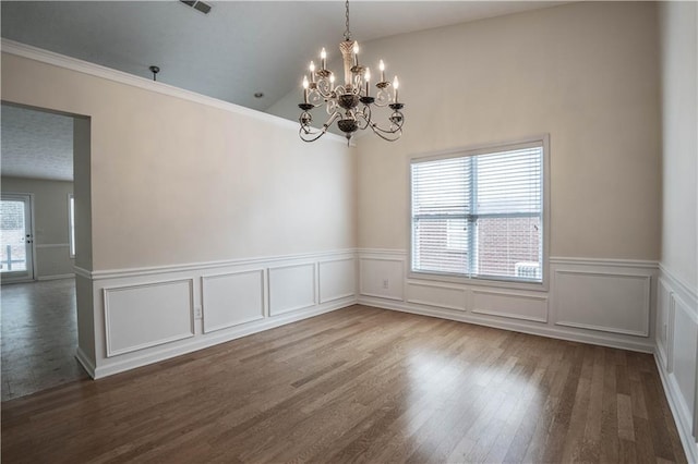 empty room featuring hardwood / wood-style flooring, a wealth of natural light, and a notable chandelier