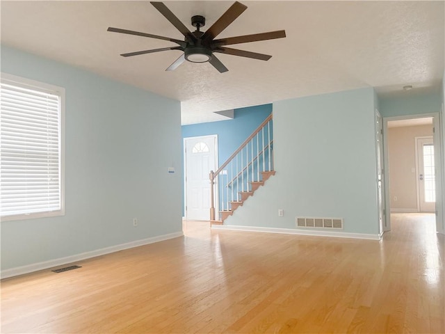 empty room with ceiling fan and light hardwood / wood-style floors