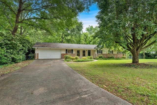 single story home featuring asphalt driveway, a garage, brick siding, and a front yard