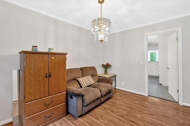 sitting room featuring ornamental molding, baseboards, light wood finished floors, and a chandelier