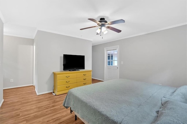 bedroom featuring ornamental molding, baseboards, light wood-type flooring, and a ceiling fan
