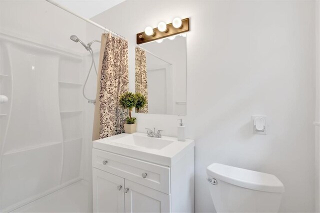 bathroom featuring a shower with curtain, vanity, and toilet