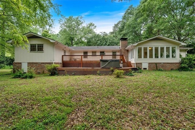 back of house featuring crawl space, a deck, a yard, and a chimney
