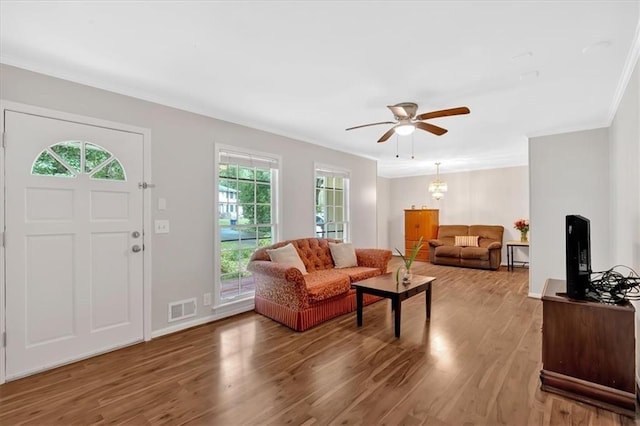 living room with crown molding, wood finished floors, and a ceiling fan