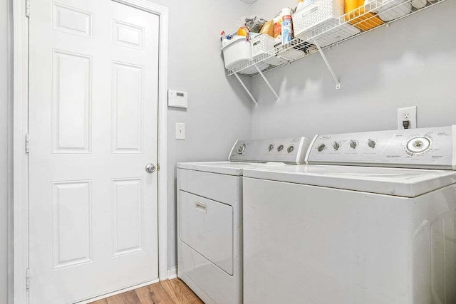 washroom with separate washer and dryer and light hardwood / wood-style flooring