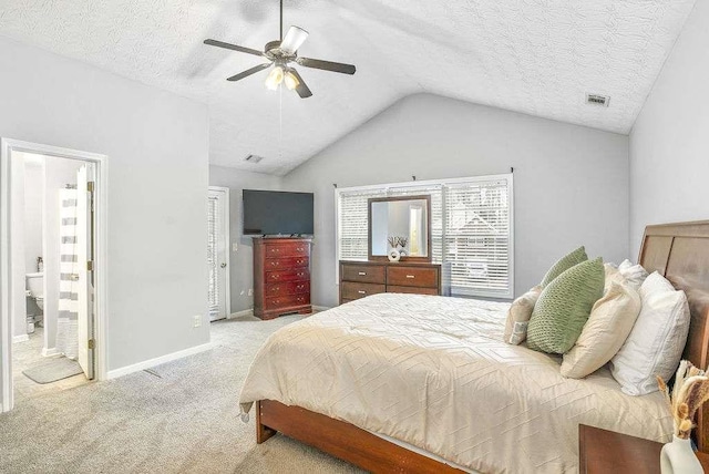 carpeted bedroom featuring ceiling fan, connected bathroom, vaulted ceiling, and a textured ceiling