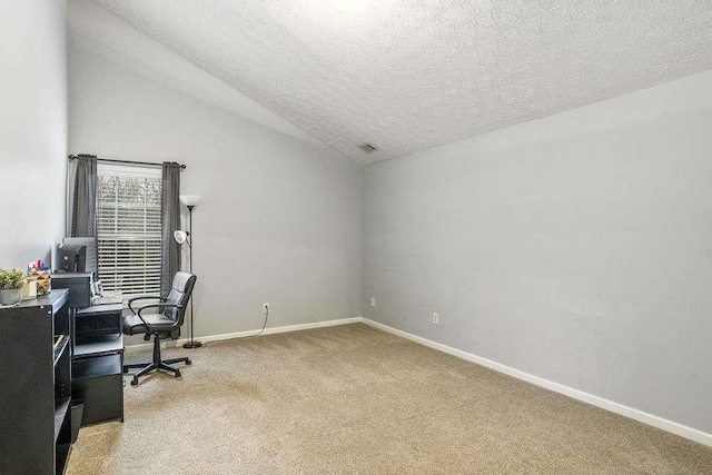 carpeted office space featuring lofted ceiling and a textured ceiling