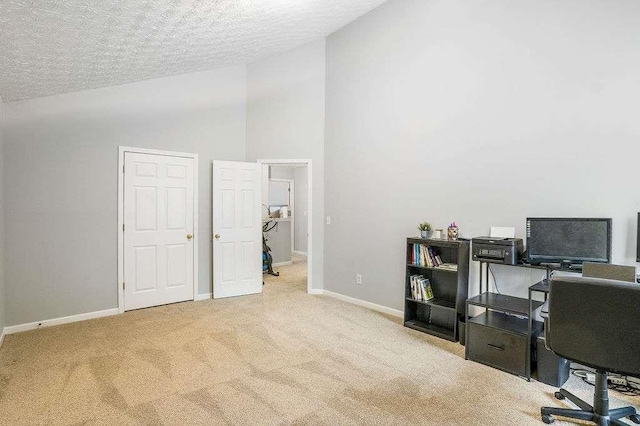 office area featuring high vaulted ceiling, light carpet, and a textured ceiling