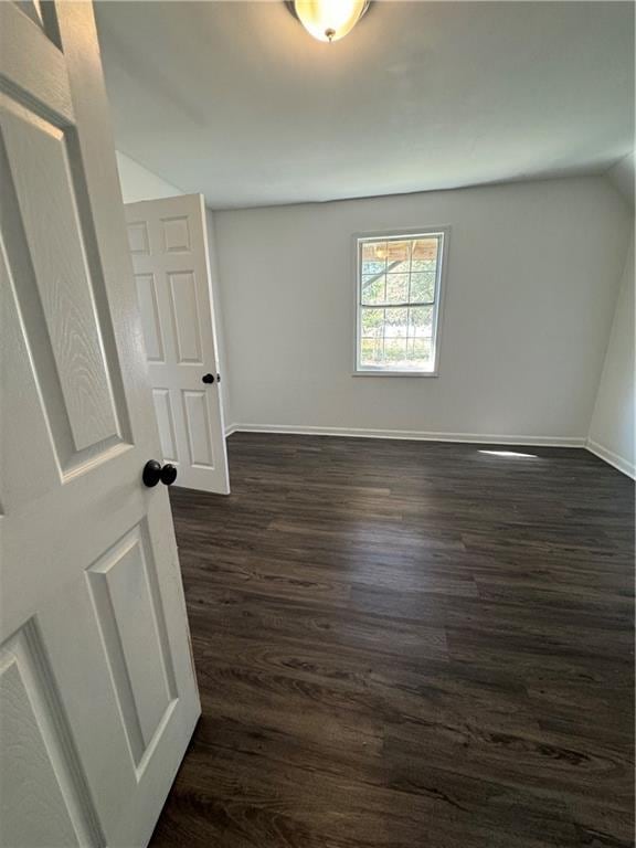 spare room featuring dark wood-type flooring