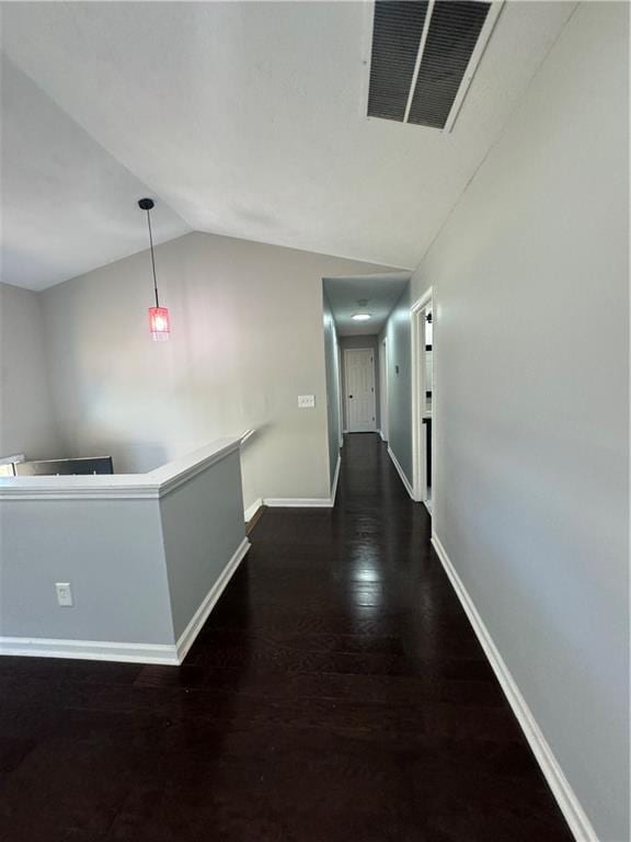 hall with dark hardwood / wood-style flooring and vaulted ceiling