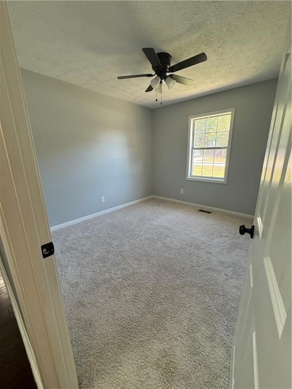 unfurnished room featuring carpet, a textured ceiling, and ceiling fan