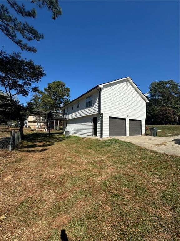 view of side of home featuring a garage and a yard