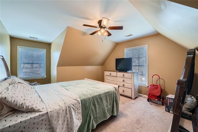 bedroom featuring ceiling fan, visible vents, vaulted ceiling, and light colored carpet