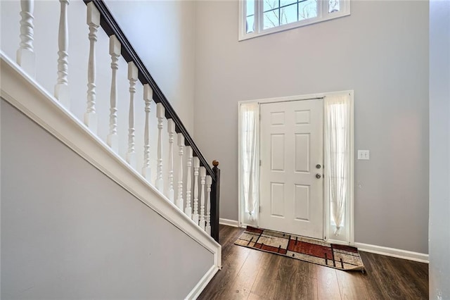 entrance foyer with a towering ceiling, stairway, baseboards, and hardwood / wood-style flooring