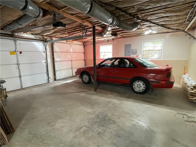 garage with a garage door opener and electric panel