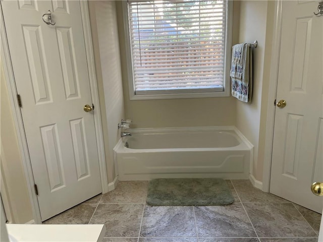 bathroom with a bath and tile patterned floors