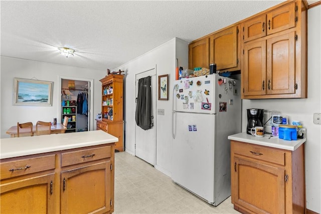 kitchen featuring white fridge and a textured ceiling