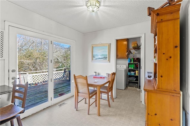 dining space with washer / dryer and a textured ceiling