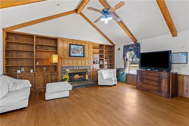 living room featuring ceiling fan, high vaulted ceiling, a fireplace, wood-type flooring, and beamed ceiling