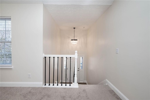 stairway with carpet flooring and a textured ceiling