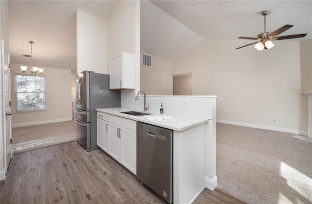 kitchen featuring white cabinetry, sink, vaulted ceiling, and appliances with stainless steel finishes