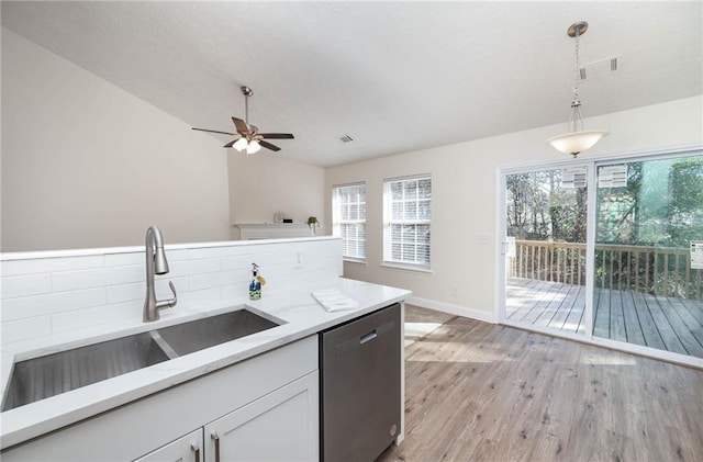 kitchen featuring dishwasher, sink, light hardwood / wood-style flooring, decorative light fixtures, and white cabinetry