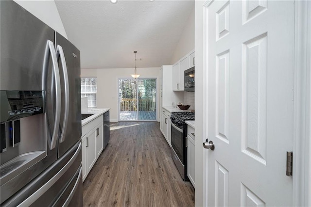 kitchen featuring white cabinetry, tasteful backsplash, dark hardwood / wood-style flooring, pendant lighting, and appliances with stainless steel finishes