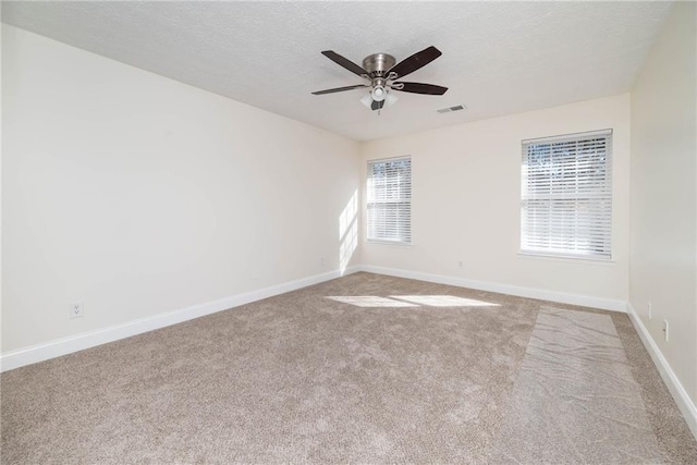 carpeted spare room with ceiling fan and a textured ceiling