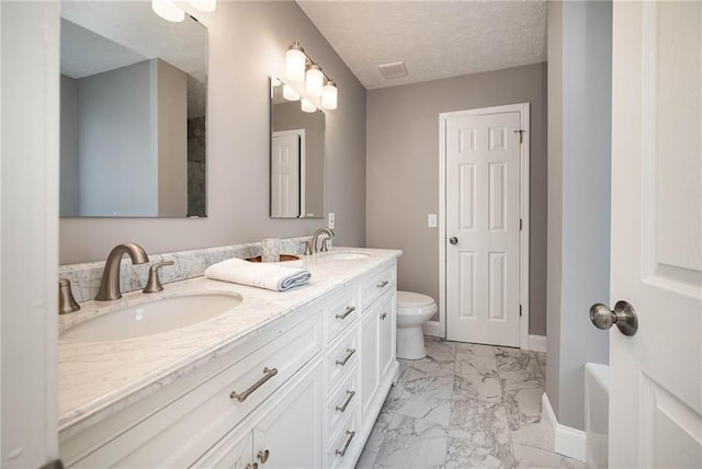 bathroom with vanity, a textured ceiling, and toilet