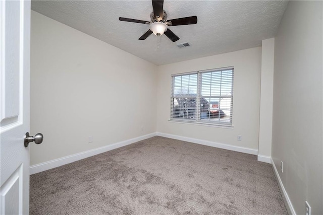 empty room featuring ceiling fan, light colored carpet, and a textured ceiling