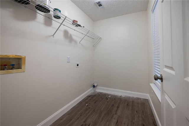 washroom with washer hookup, a textured ceiling, dark wood-type flooring, and electric dryer hookup