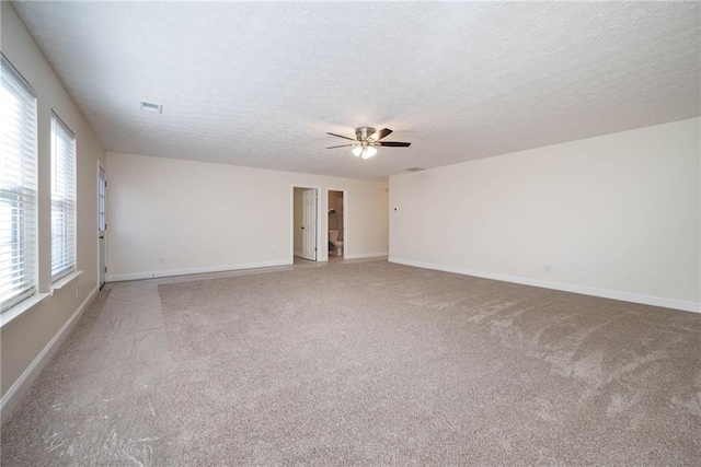 carpeted spare room with ceiling fan and a textured ceiling