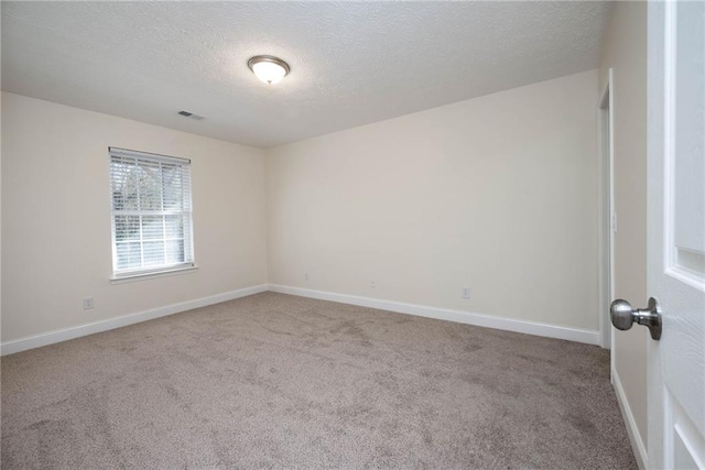 carpeted empty room with a textured ceiling