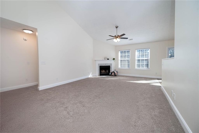 unfurnished living room featuring a premium fireplace, ceiling fan, light carpet, and lofted ceiling