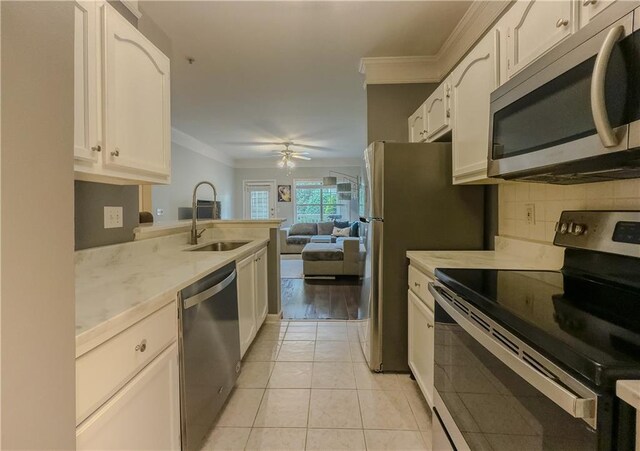 2700 Pine Tree Rd NE Unit 1013, Atlanta, GA 30324 - kitchen featuring stainless steel appliances, ornamental molding, light countertops, and white cabinets